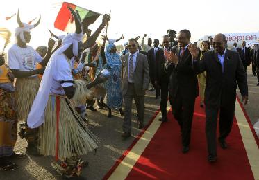 Ethiopia's Prime Minister Hailemariam Desalegn (C) and Sudan's President Omar al-Bashir (R) react to traditional performers as Desalegn arrives at Khartoum airport December 3, 2013. (Photo Reuters/Mohamed Nureldin Abdallah)