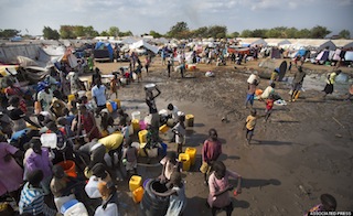 Displaced people gather around a water truck to fill containers at a United Nations compound which has become home to thousands of people displaced by the recent fighting, in the capital Juba, South Sudan Sunday, Dec. 29, 2013. (AP Photo/Ben Curtis)