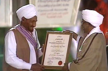 Leader of the National Umma Party al-Sadiq al-Mahdi (L) receiving the Order of the Republic from Sudanese president Omer Hassan Al-Bashir (R) in Khartoum on 31 December 2013 (Ashorooq TV)
