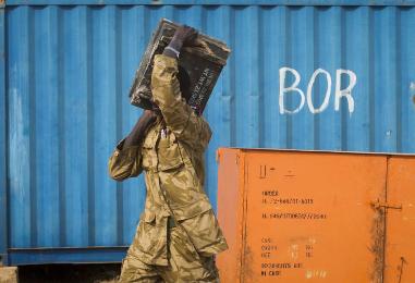 A South Sudanese government soldier carries an ammunition box from storage at the airport in Jonglei state capital Bor on 19 January 2014 (Photo: AP/Mackenzie Knowles-Coursin)