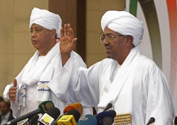 Sudanese president Omer Hassan al-Bashir (R), flanked by presidential assistant Ibrahim Ghandour, gives a speech in the Sudanese capital, Khartoum, on 27 January 2014 (Photo: AP/Abd Raouf)