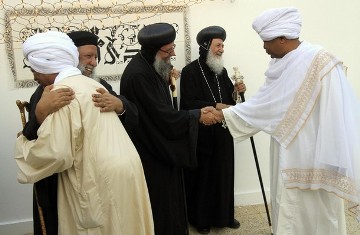 Coptic priests (in black) welcome Muslim guests at an iftar, or the breaking of the fast, dinner organized by Sudanese Copts at the Coptic Club during Ramadan in Khartoum August 23, 2010 (REUTERS/Mohamed Nureldin Abdallah)