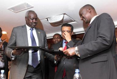 South Sudan's leader of the government's delegation Nhial Deng Nhial (L) exchanges a signed ceasefire agreement with the head of the rebel delegation Taban Deng Gai (R) in Addis Ababa, January 23, 2014. ( Photo Reuters/Birahnu Sebsibe)