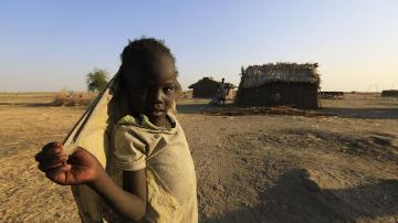 A South Sudanese girl looks on near a shelter in al-Ghanaa village in the Jableen locality in Sudan's White Nile State, as refugees arrive from the South Sudanese war zones of Malakal and al-Rank via the Joda border, January 17, 2014 (REUTERS/Mohamed Nureldin Abdallah)