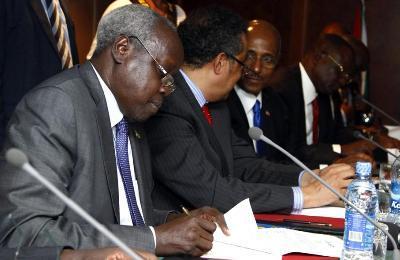 The leader of South Sudan's government's delegation, Nhial Deng Nhial (L), signs a ceasefire agreement aimed at ending conflict in the country following negotiations in the Ethiopian capital, Addis Ababa, on 23 January 2014 (Photo: Reuters/Birahnu Sebsibe)