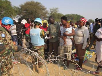 People seeking shelter at the UNMISS compound in Jonglei capital Bor wait in line as UN military police conduct security checks (Photo courtesy of UNMISS)