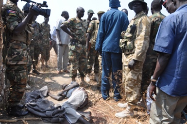 Officials surround the body of Job Mading Deng, who was killed during Wednesday's attack on Kolnyang village, north-east of Jonglei state capital Bor (ST)