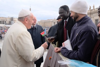 Pope Francis recieves the flag of South Sudan from Choul Laam (Vatican photo)