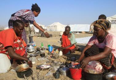 South Sudanese refugees cook on an open fire at a camp run by the Sudanese Red Crescent Society in the western part of White Nile state, Sudan, on January 27, 2014 (Photo AFP/Ashraf Shazly)