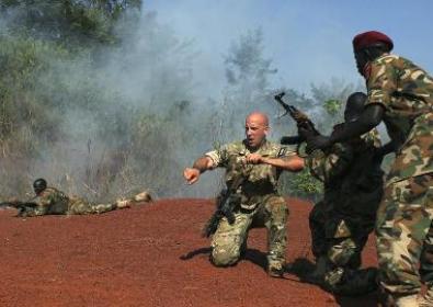 A U.S. Special Forces trainer supervises a military assault drill for a  SPLA unit  conducted in Nzara on the outskirts of Yambio November 29, 2013. (Photo Reuters/Andreea Campeanu)