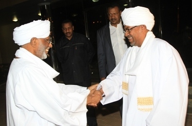 Sudanese president Omer Al-Bashir shakes hands with Hassan Al-Turabi, leader of the opposition Popular Congress Party in Khartoum on 14 March 2014 (SUNA)