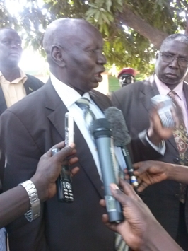 Daniel Awet Akot (L), former deputy speaker of South Sudan’s national assembly and the current deputy chairperson of the Crisis Management Committee (CMC), speaks to the press after a public rally in Nimule, as Jonglei state’s minister of local government, Ding Akol, Ding looks on, 15 March 2014 (ST)