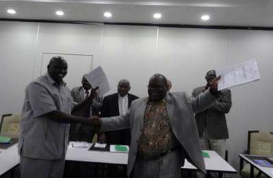 Top rebel negotiator Boutros Khalid (L)  shakes hands with the head of government negotiating team, Canon Clement Janda,  after the signing of a peace deal in Addis Ababa on 28 March 2014 (Photo ST)