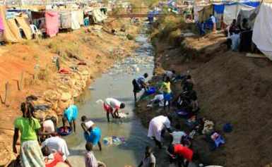 Displaced people wash their clothes in a drainage canal at Tomping camp, in the South Sudan capital, Juba, on 7 January 2014 (Photo: Reuters/James Akena)