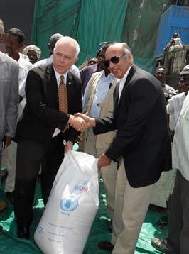 The acting charge d'affaires of the US embassy in Khartoum, Christopher Rowan (L), and WFP country director Adnan Khan welcome a shipment of food donated by USAID in Port Sudan on 27 April 2014 (ST)