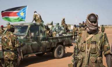 A South Sudanese government soldier stands in front of a vehicle in South Sudan's Unity State on 12 January 2014 (AP)