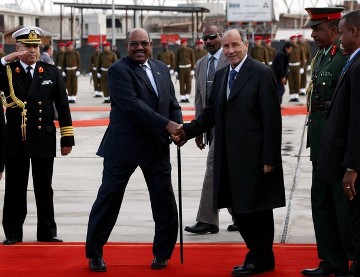 Libya's National Transitional Council's chief, Mustafa Abdel Jalil (R) shakes hands with Sudanese President Omar al-Bashir (L) upon Bashir's arrival at Tripoli International Airport on January 7, 2012 (MAHMUD TURKIA/AFP/Getty Images)