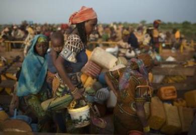 CAR Women carry their belongings as they disembark from trucks carrying refugees Muslims, after travelling in convoy escorted by the African Union troops on a 4-day journey from Bangui, to Chad border town of Sido, April 30, 2014. (Photo Reuters/Siegfried Modola)