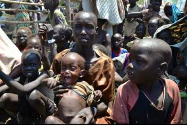 South Sudan’s Nyaman Joak holds her 16-month-old child as she waits to be registered as refugee at Ethiopia’s Pagak entry point after walking 10 days from her home in Upper Nile state (Photo: WFP/Lisa Bryant)