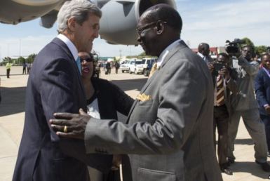 US secretary of state (L) is greeted by South Sudan's foreign minister, Barnaba Marial Benjamin, on his arrival in the capital, Juba, on 2 May 2014 (AP)