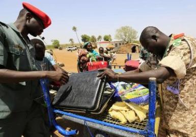 Sudanese military personnel inspect the belongings of South Sudanese on the Sudanese border on 18 April 2014 (Photo: Reuters/Mohamed Nureldin Abdallah)