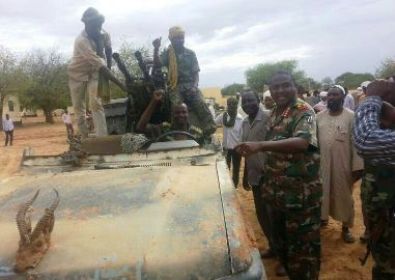 Sudanese army officer points to Ali Karbino's vehicle, captured after the killing of the rebel leader in North Darfur on 27 June 2014 (ST)