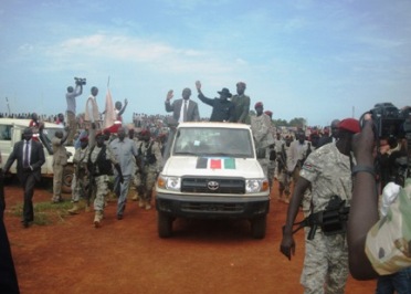 South Sudanese president Salva Kiir (R) with the governor of Western Bahr el Ghazal state,  Rizik Zackaria Hassan, wave to the crowd from the back of a car during a visit to the capital, Wau, on 16 July 2014 (ST)