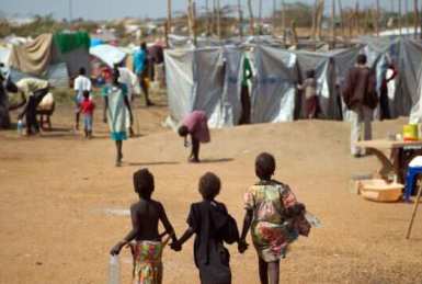 Children walk through a camp for internally displaced persons at the United Nations Mission to South Sudan (UNMISS) base in the capital, Juba, on 9 January 2014 (AFP)