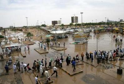 Sudanese people try to walk at a flooded bus station in Khartoum on 3 August 2014 (Photo: AFP/Anadolu Agency/Ebrahim Hamid)