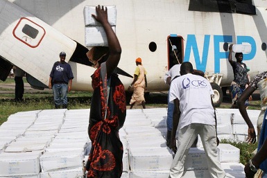 CRS staff unload food from a World Food Programme helicopter and distribute it to families displaced by recent violence in South Sudan (Photo: Donal Reilly/CRS)