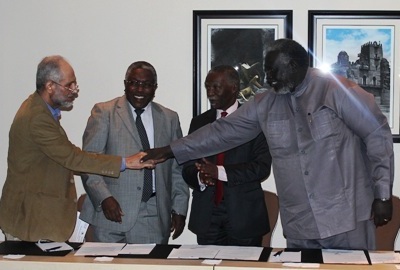 SRF leader Malik Agar (R) and Ghazi Salah al-Din of the 7+7 Committee shakes hands in the Ethiopian capital, Addis Ababa, while AUHIP and the other dialogue committee members applaud on 5 September 2014  (Photo courtesy of the AUHIP)