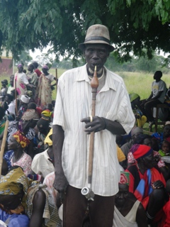 An old man using his long traditional smoking pipe in front of Twic East county community members on 14 July 2014 (ST)