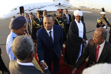 The Libyan prime minister shakes hands with Sudanese foreign minister Ali Karti after his arrival to Khartoum on 27 October 2014 (Photo: AFP/Ashraf Shazly)