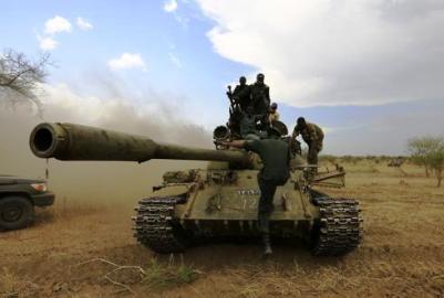 Sudanese army soldiers and  RSF militiamen ride on a tank outside the military headquarters in Kadugli, South Kordofan after recapturing the Daldako area on 20 May 2014 (Photo: Reuters/Nureldine Abdallah)