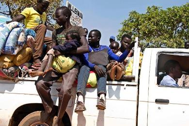 South Sudanese refugees fleeing violence in their home country wait to be transported to Uganda's Arua district settlement camp on 6 January 2014 (Photo: AFP/Isaac Kasamani)
