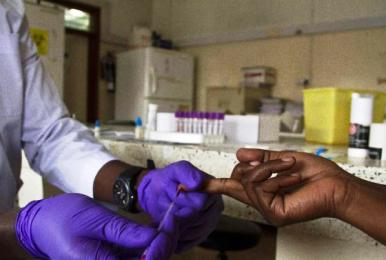 A lab technician draws blood from a patient for HIV testing at the Aids Information Centre in Kampala on 20 January 2014 (AFP)