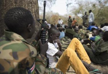 Child soldiers sit with their rifles at a ceremony held on 10 February 2015 as part of a disarmament campaign overseen by UNICEF and partners in Pibor (AFP)