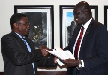 AJOC co-chairs Hassan Ali Nimir (L) and (Deng Mading Mijak) shake hands following the signing of the resolution exchange on 30 March 2015 (Photo courtesy of the AUHIP)