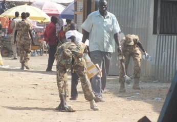 South Sudanese army (SPLA) officers pick up rubbish in Bor market after the planned demolition of shops and houses was postponed on 28 February 2015 (ST)