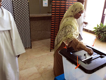 سيدة تدلي بصوتها في مركز إقتراع بسفارة السودان في العاصمة العمانية مسقط