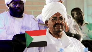 Sudanese pesident Omer Hassan al-Bashir holds a national flag during a campaign rally ahead of the 2015 elections in Omdurman on 9 April 2015 (Photo: Reuters)