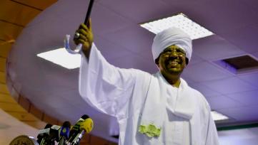 Sudanese president Omer Hassan al-Bashir raises his arm as his supporters cheer at his victory speech after he won the presidential election at the National Congress Party headquarters in Khartoum, Sudan, Monday, April 27, 2015 (AP Photo/Jason Patinkin)