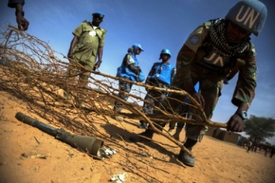 A UNAMID peacekeeper uses branches to mark the location of a mortar projectile abandoned inthe Abassi camp for IDPs in Mellit, N Darfur (Photo UNAMID/Albert González Farran)