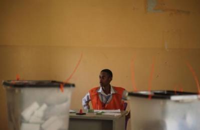 An election official at a polling station on the first day of Sudan's presidential and legislative elections in Izba, an impoverished neighbourhood on the outskirts of Khartoum, on 13 April 2015 (Photo: AP/Mosa'ab Elshamy)