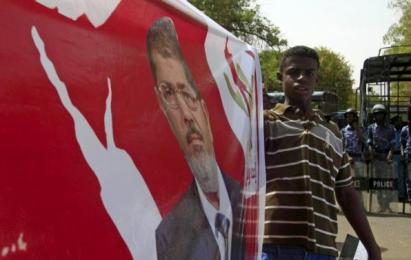 A man holds a banner with the image of Egypt's ousted Islamist president Mohamed Morsi as protesters march against an Egyptian court's decision this week to seek the death penalty for Morsi, after Friday prayers in Khartoum, May 22, 2015 (Reuters Photo)