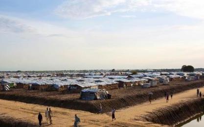 People walk through the United Nations base outside Bentiu, which hosts around 118,000 people uprooted during the country's 21-month old civil war (Photo AFP/Tristan McConnell)