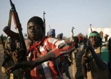 Rebel fighters hold their weapons as they march through a village in rebel-controlled territory in South Sudan’s Upper Nile state on 9 February 2014 (Photo: Reuters)