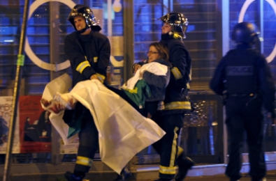 French fire brigade members aid an injured individual near the Bataclan concert hall following fatal shootings in Paris on 13 November 2015 (Photo Reuters)