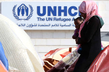 لاجئة سودانية تحمل طفلها في مخيم أمام المفوضية السامية لشؤون اللاجئين بعمان ـ صورة من موقع 