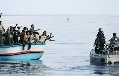 Members of the Maltese armed forces toss bottles of water to a group of around 180 illegal immigrants after their vessel ran into engine trouble, off the coast of Malta on September 25, 2005 (Photo Reuters/Darrin Zammit Lupi)